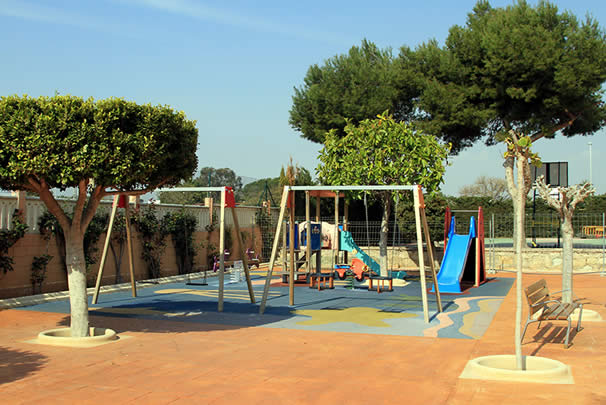 Zona infantil con columpios y toboganes